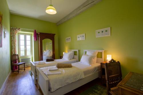a bedroom with two beds with green walls at La Gironie in Pomport