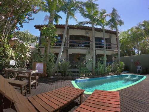 a resort with a swimming pool and a building at Pousada El Pátio da Ferrugem uma quadra da praia in Garopaba