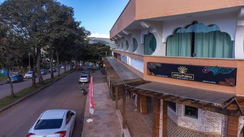 a building on the side of a street with cars parked at Villa Terragona in Alto Paraíso de Goiás