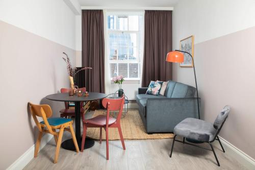 a living room with a table and chairs and a couch at Bob W London Spitalfields in London