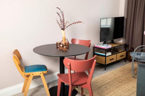 a room with a table and chairs and a tv at Bob W London Spitalfields in London