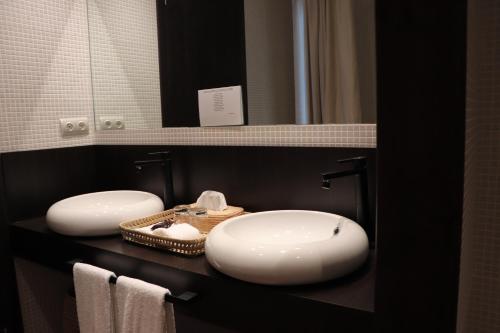 a bathroom with two sinks and a mirror at Balneario Segura de Baños in Segura de los Baños