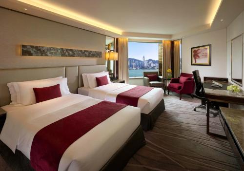 a hotel room with two beds and a desk at InterContinental Grand Stanford Hong Kong by IHG in Hong Kong