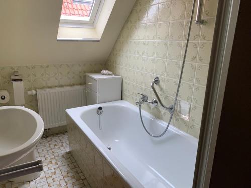 une salle de bain avec baignoire et toilettes dans l'établissement Strandlöper Ferienhaus, à Dangast