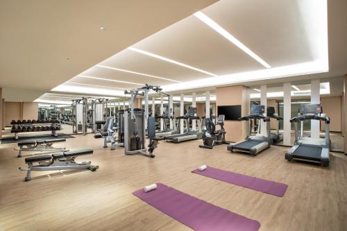 a gym with several treadmills and exercise machines at Holiday Inn Shanghai Dishui Lake by IHG in Nanhui