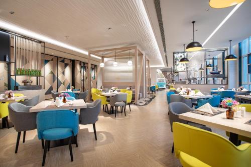 a restaurant with tables and chairs in a cafeteria at Holiday Inn Shanghai Dishui Lake by IHG in Nanhui