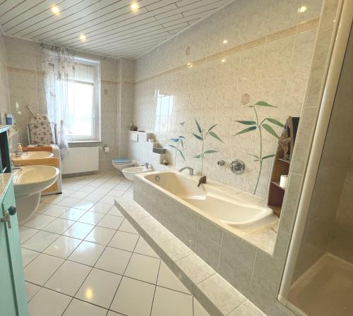 baño con 2 lavabos, bañera y 2 aseos en Attraktive 2 Zimmer Wohnung in Toplage, Nähe Messe, en Hannover