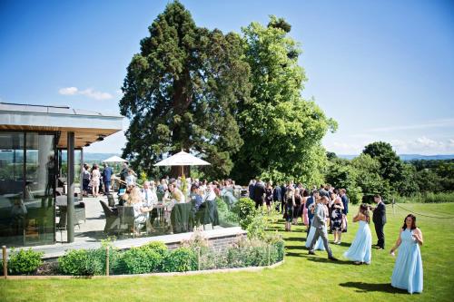 a group of people walking around a garden at Tewkesbury Park in Tewkesbury