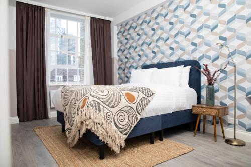 a bedroom with a blue and white bed and a window at Bob W Commercial House in London