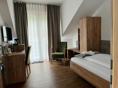 a bedroom with a bed and a desk and a chair at Hotel Knotenpunkt in Meppen