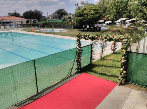 a swimming pool with a red carpet next to a fence at Hotel Peña Cruz in Malpartida de Cáceres