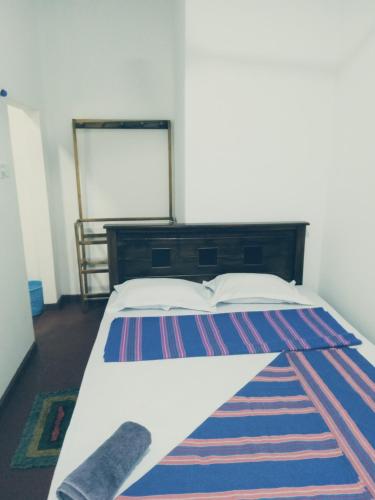 a bedroom with a bed with a rug on the floor at Kasun Hotel in Koslanda
