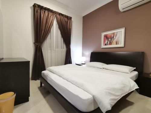 a bedroom with a large white bed and a window at Al Muftah Homes in Doha