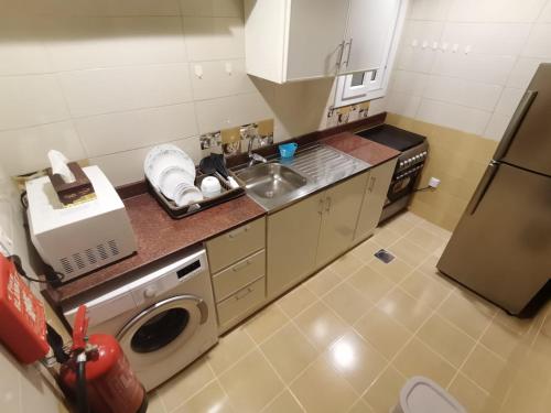 eine kleine Küche mit Spüle und Kühlschrank in der Unterkunft Al Muftah Homes in Doha