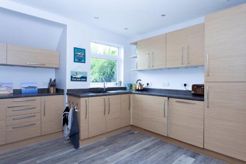 a kitchen with wooden cabinets and a sink and a window at Magnolia cove in Whitstable