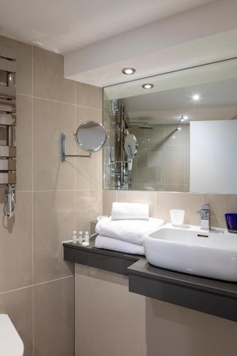 a bathroom with a sink and a mirror at Tewkesbury Park in Tewkesbury
