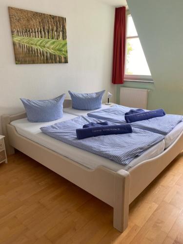 Una cama grande con almohadas azules encima. en 2 Zimmer Appartement Ostseeblick, en Boltenhagen