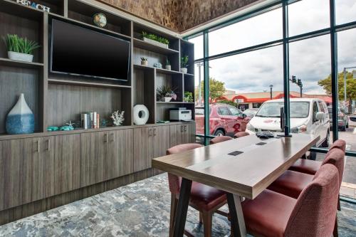 a dining room with a table and chairs and a tv at Holiday Inn Va Beach-Oceanside 21st St by IHG in Virginia Beach