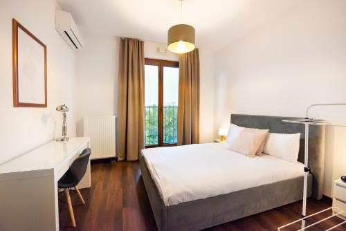 um quarto com uma cama, uma secretária e uma janela em Magazynowa Contemporary Apartment em Varsóvia