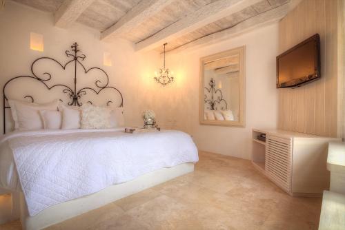 sypialnia z białym łóżkiem i telewizorem w obiekcie Casa Logos Hotel Boutique w mieście Cartagena de Indias