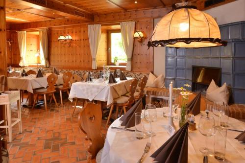 uma sala de jantar com mesas e cadeiras e um lustre em Landhotel Gressenbauer em Hinterstoder