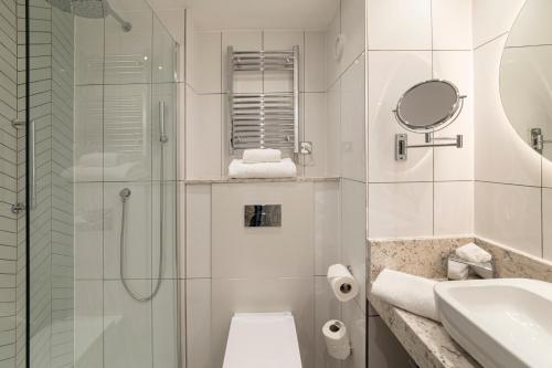 a bathroom with a shower and a toilet and a sink at Tewkesbury Park in Tewkesbury