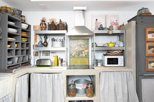 a kitchen with white shelves and a refrigerator at La Casuca in Vejer de la Frontera