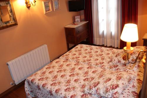 a bedroom with a bed and a lamp and a window at Hotel Casa Prendes in Cudillero