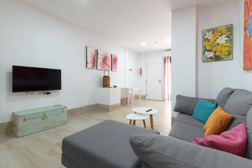 sala de estar con sofá y TV en loft a 3 minutos bus y tren, en Málaga