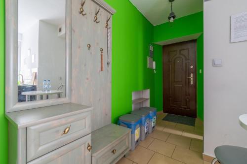 a green bathroom with a sink and a mirror at Apartament Morcinka in Bytom