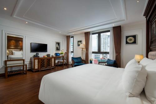 sypialnia z białym łóżkiem i salonem w obiekcie The Q Hotel w mieście Hanoi