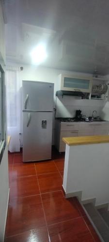 a kitchen with a refrigerator and a wooden floor at El mirador Raquireño ma in Ráquira