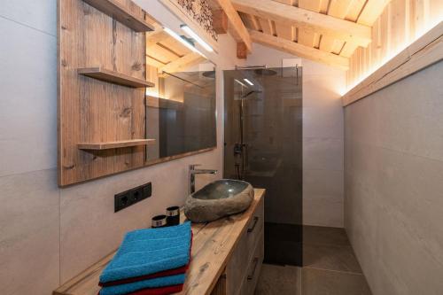 uma casa de banho com um lavatório e uma cabina de duche em vidro. em Ferienhütte Sternenblick em Grosskirchheim