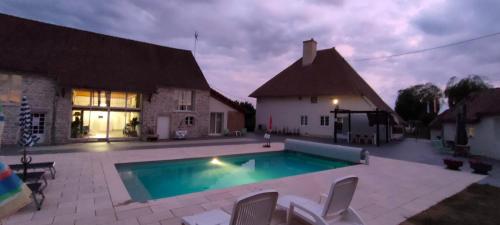 une piscine devant une maison la nuit dans l'établissement Domaine Ravy-Orchidée, à Saint-Symphorien-sur-Saône