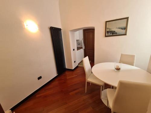 une salle à manger avec une table et des chaises blanches dans l'établissement LE MURA, à Gênes