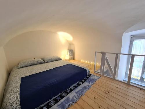 a bedroom with a bed with a blue blanket at LE MURA in Genoa