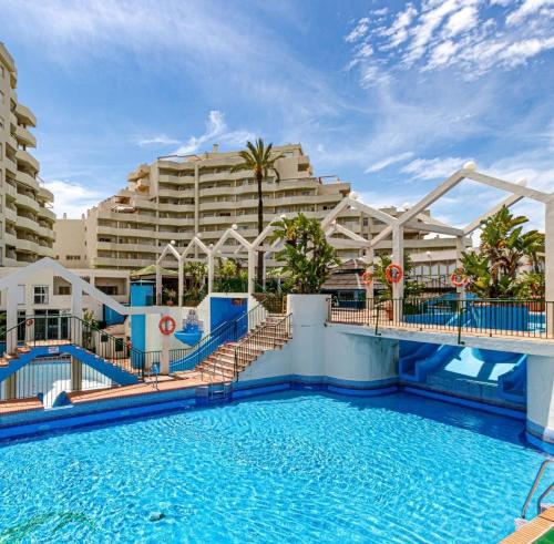 uma piscina num resort com um grande edifício em Apartamentos HOLIDAYS BENALBEACH em Benalmádena