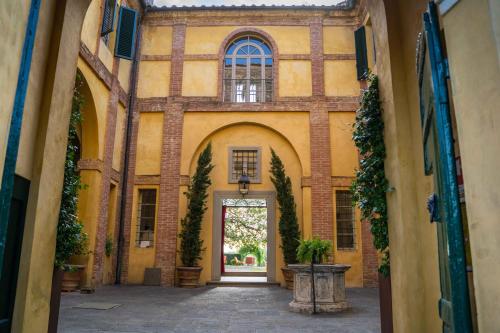 wejście do budynku z drzwiami i dziedzińcem w obiekcie Hotel Certosa Di Maggiano w Sienie