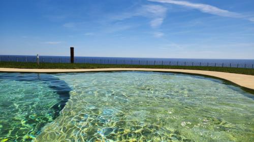 a swimming pool with the ocean in the background at Cluxury-Torre dei Saraceni BOUTIQUE APT BY THE SEA Beach, Pool,Private Jacuzzi, Parking in Cervo