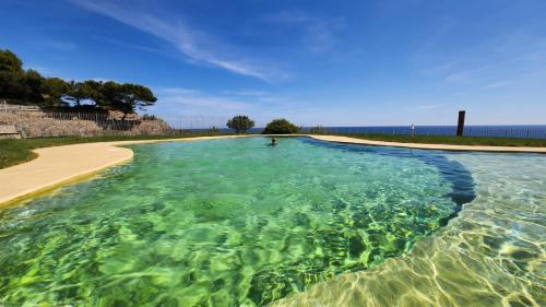 una grande piscina d'acqua accanto a una spiaggia di Cluxury-Torre dei Saraceni BOUTIQUE APT BY THE SEA Beach, Pool,Private Jacuzzi, Parking a Cervo