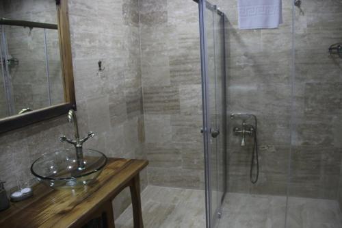a bathroom with a glass shower and a sink at Vigneron Cave Hotel in Nevsehir