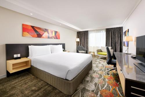 a hotel room with a bed and a television at Holiday Inn Perth City Centre by IHG in Perth