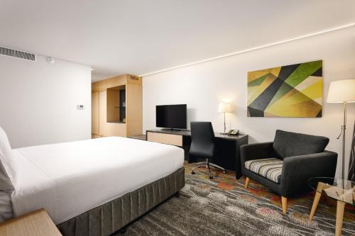 a hotel room with a bed and a desk and chair at Holiday Inn Perth City Centre by IHG in Perth