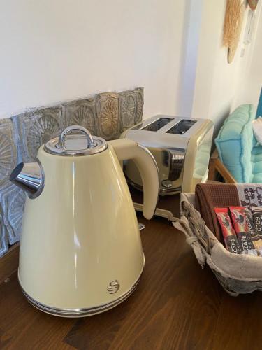 a yellow tea kettle sitting on the floor next to a toaster at Sunside Inn Hotel in Kyrenia