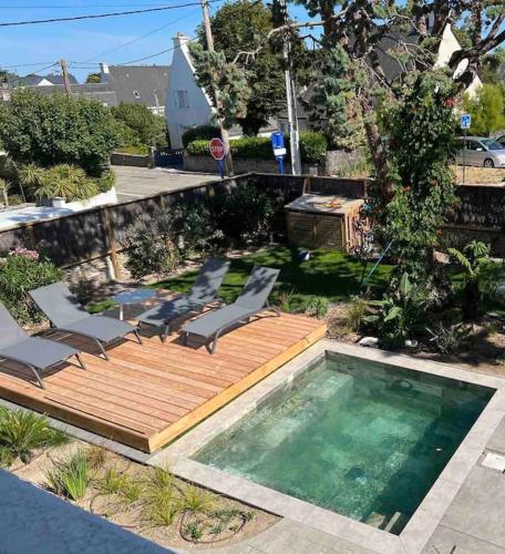 une terrasse en bois avec des chaises et une piscine dans l'établissement Villa Salicorne, à Quiberon