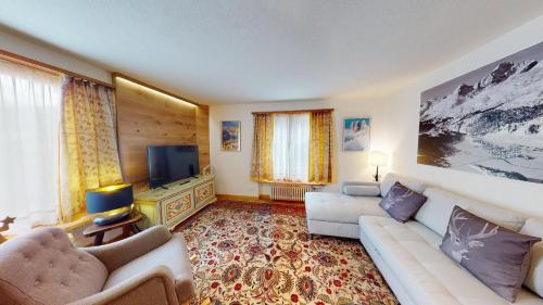a living room with a couch and a tv at Chesa Centrum in Celerina