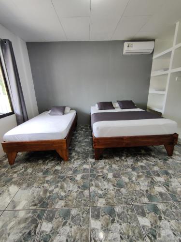 two beds sitting next to each other in a room at Cabinas Maritza in Quebrada Ganado