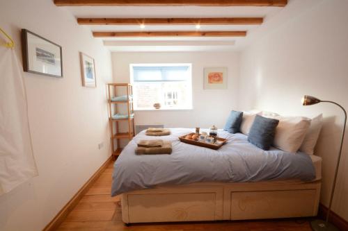 a bedroom with a large bed with a tray on it at Vesta Cottage, Orford in Orford