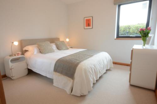 a bedroom with a large bed and a window at Upper Lodge, Shotley 