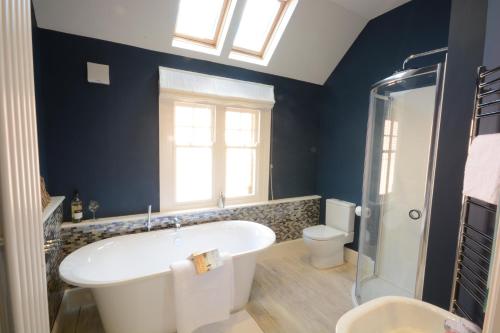 ein Badezimmer mit einer großen Badewanne und einem WC in der Unterkunft Holly Lodge in Aldeburgh